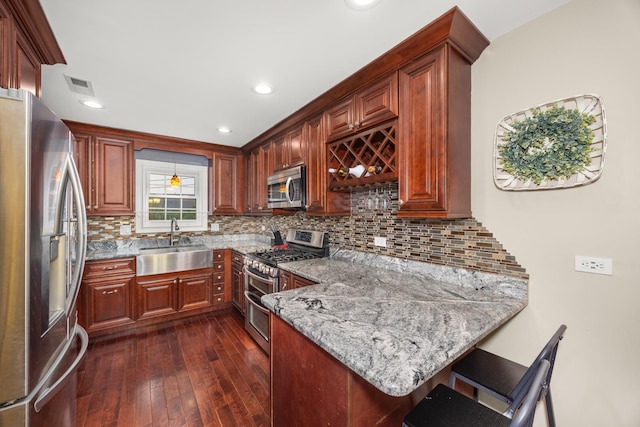 11030 S Nagle Ave, Worth, IL 60482 - kitchen with appliances with stainless steel finishes, a sink, a peninsula, dark wood-type flooring, and light stone counters