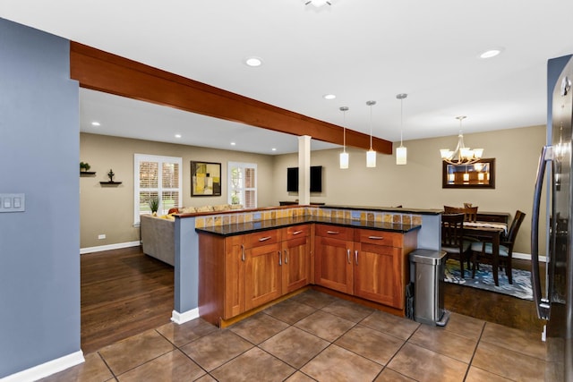 1101 Juniper Ter, Glenview, IL 60025 - kitchen with freestanding refrigerator, a chandelier, hanging light fixtures, open floor plan, and dark tile patterned floors