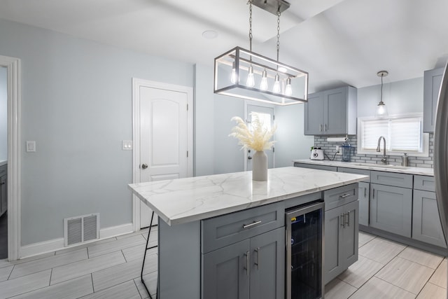 5648 S California Ave, Chicago, IL 60629 - kitchen featuring wine cooler, a sink, gray cabinets, backsplash, and light stone countertops