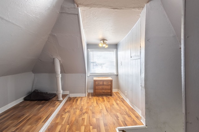 5648 S California Ave, Chicago, IL 60629 - bonus room with light wood finished floors, baseboards, lofted ceiling, and a textured ceiling