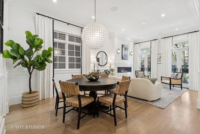 1963 N Dayton St, Chicago, IL 60614 - dining space with light wood finished floors, a decorative wall, a glass covered fireplace, ornamental molding, and a chandelier