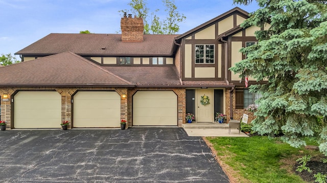 13253 S Oak Ridge Trl Unit 2B, Palos Heights, IL 60463 - english style home featuring a chimney, driveway, a shingled roof, brick siding, and an attached garage