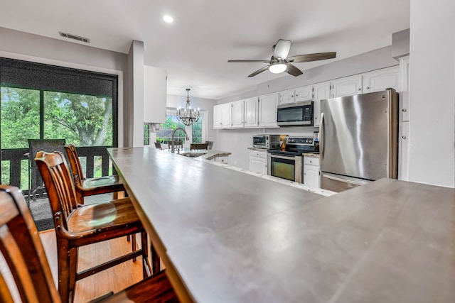 13253 S Oak Ridge Trl Unit 2B, Palos Heights, IL 60463 - kitchen featuring stainless steel counters, appliances with stainless steel finishes, a peninsula, a ceiling fan, and white cabinets