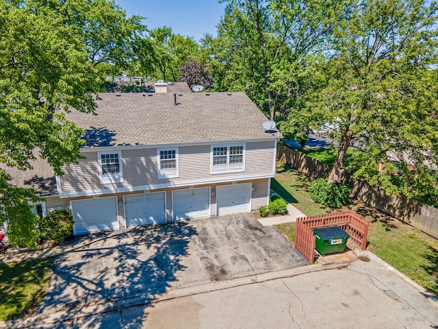 1206 Spur Ct Unit 1206, Wheeling, IL 60090 - view of front of home featuring driveway, a shingled roof, and a garage