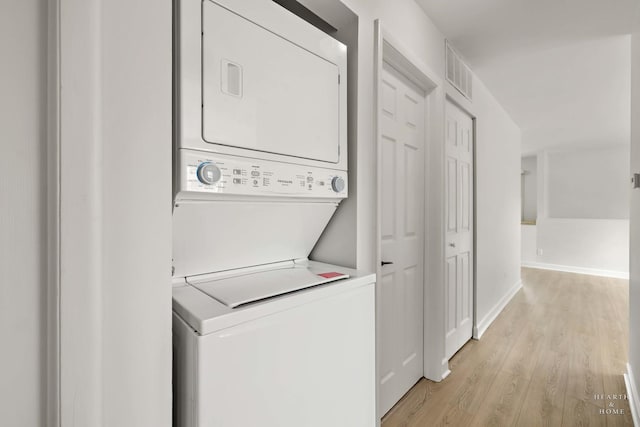 1206 Spur Ct Unit 1206, Wheeling, IL 60090 - laundry area featuring stacked washing machine and dryer, light wood-style flooring, and baseboards