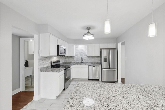 2311 183rd St Unit 203, Homewood, IL 60430 - kitchen with appliances with stainless steel finishes, tasteful backsplash, white cabinetry, and light stone countertops