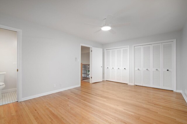 9140 Keystone Ave, Skokie, IL 60076 - unfurnished bedroom featuring two closets, baseboards, light wood-style floors, ensuite bath, and a ceiling fan