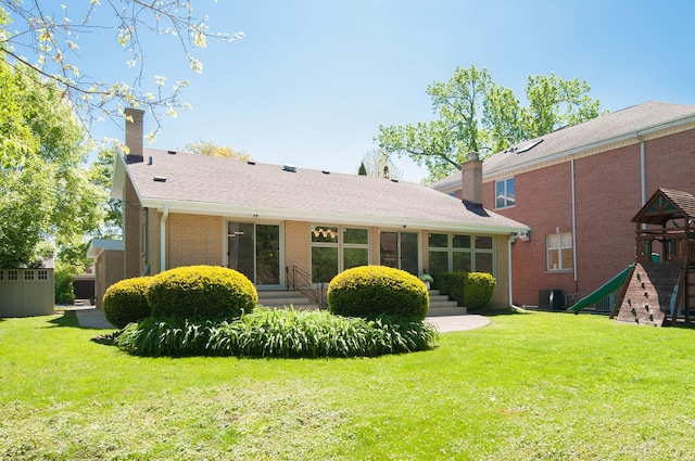 9140 Keystone Ave, Skokie, IL 60076 - rear view of property featuring a chimney, a playground, a yard, brick siding, and central AC