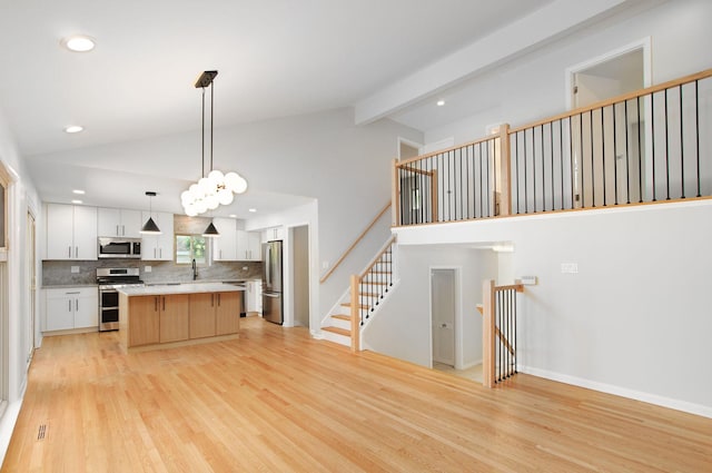 9140 Keystone Ave, Skokie, IL 60076 - kitchen with stainless steel appliances, light wood-style flooring, tasteful backsplash, a center island, and white cabinets