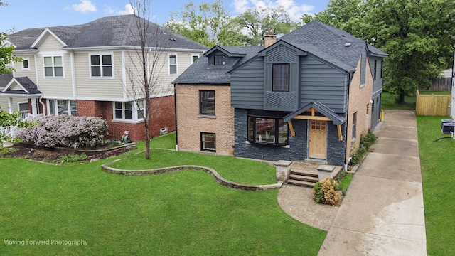 611 S Fern Ave, Elmhurst, IL 60126 - view of front of home with a chimney, brick siding, a shingled roof, and a front yard