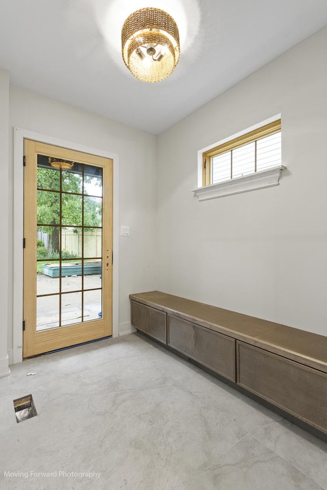 611 S Fern Ave, Elmhurst, IL 60126 - empty room featuring plenty of natural light, concrete floors, and a chandelier