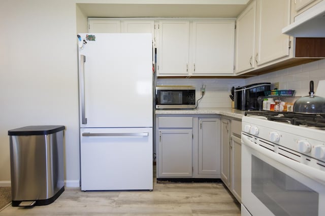 358 Princeton Ave, Bourbonnais, IL 60914 - kitchen with white appliances, under cabinet range hood, light countertops, decorative backsplash, and light wood finished floors