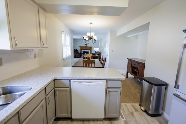 358 Princeton Ave, Bourbonnais, IL 60914 - kitchen featuring white appliances, a peninsula, backsplash, light countertops, and light wood-style flooring