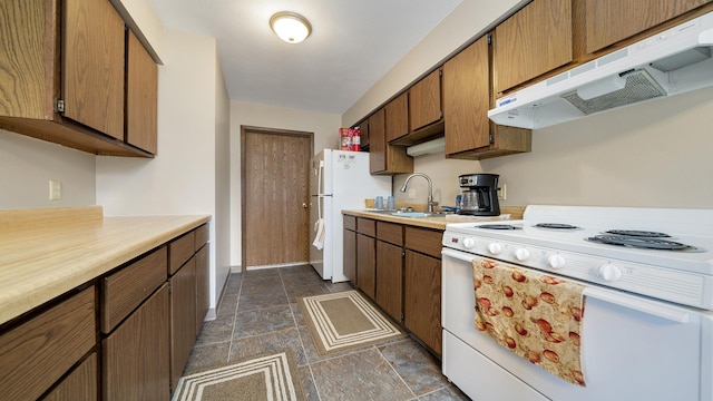 701 W Oregon St, Polo, IL 61064 - kitchen with white appliances, under cabinet range hood, a sink, light countertops, and dark stone finish flooring