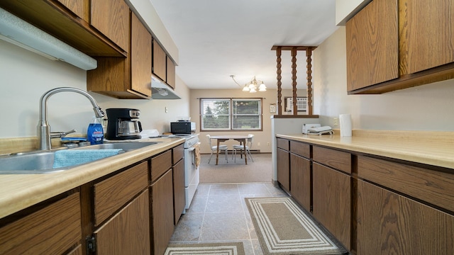 701 W Oregon St, Polo, IL 61064 - kitchen with a sink, white range with electric stovetop, a chandelier, light countertops, and light colored carpet