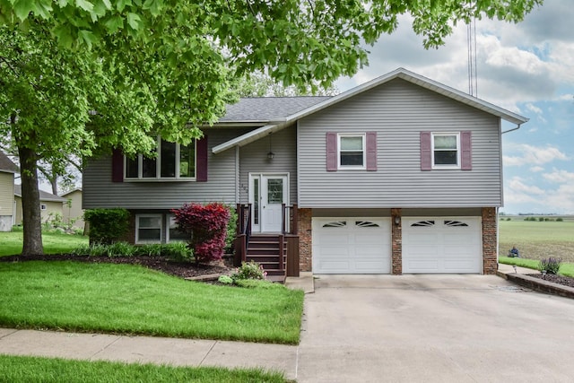 300 N Elm St, Odell, IL 60460 - bi-level home with a garage, concrete driveway, a front lawn, and a shingled roof