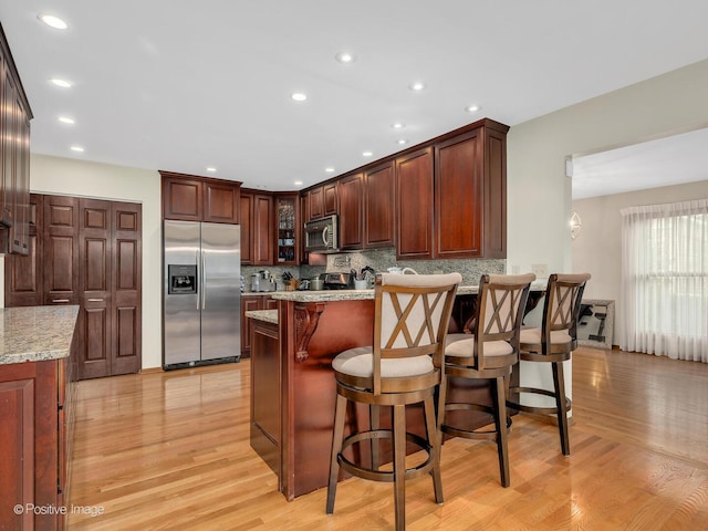 1000 Surrey Ln, Itasca, IL 60143 - kitchen featuring stainless steel appliances, a peninsula, light wood-style flooring, backsplash, and recessed lighting