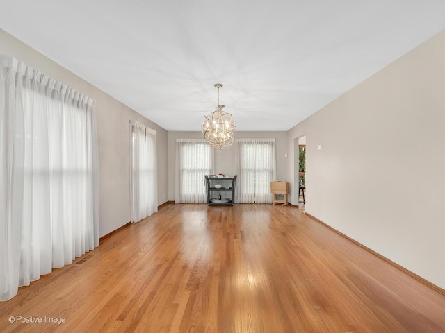1000 Surrey Ln, Itasca, IL 60143 - unfurnished living room featuring a chandelier and light wood-style floors