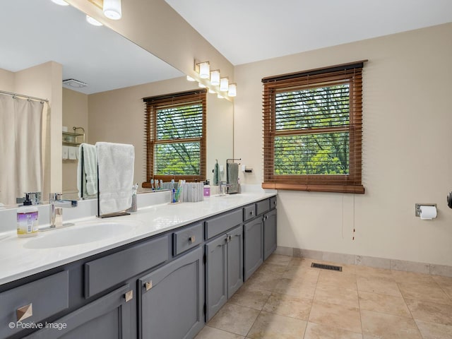 1000 Surrey Ln, Itasca, IL 60143 - bathroom with double vanity, healthy amount of natural light, baseboards, and tile patterned flooring
