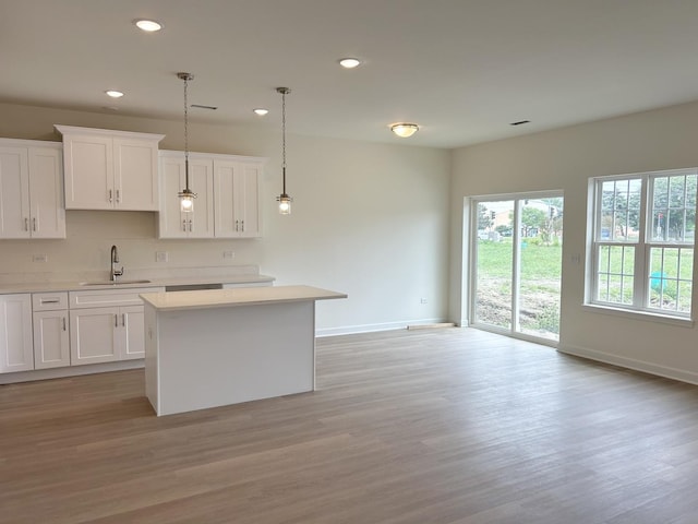 5400 135th St, Crestwood, IL 60418 - kitchen with a kitchen island, recessed lighting, light countertops, light wood finished floors, and white cabinetry