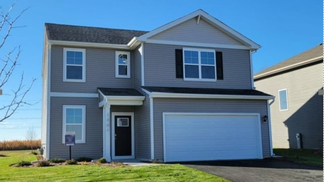 view of front facade featuring a garage, a front lawn, and asphalt driveway