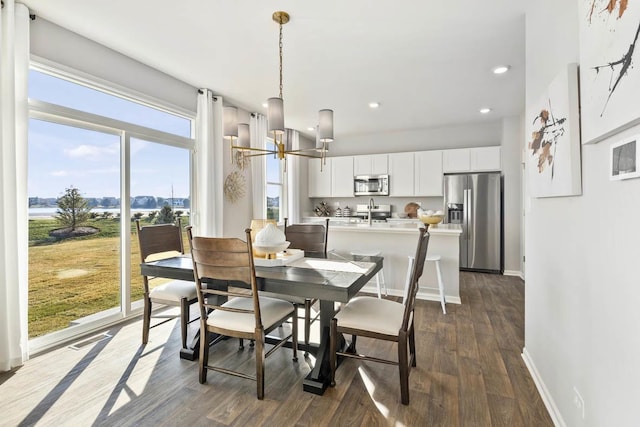 dining space with a chandelier, dark wood-style floors, recessed lighting, and baseboards