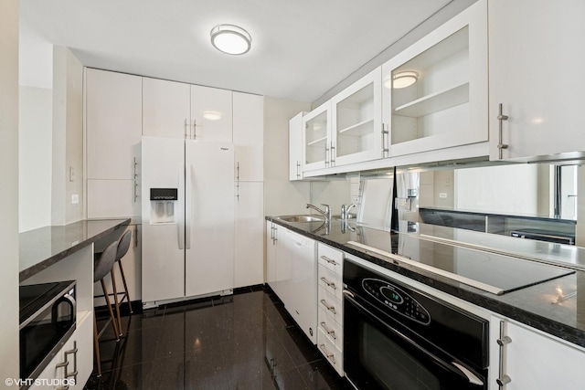 1560 N Sandburg Ter Unit 3506J, Chicago, IL 60610 - kitchen with black appliances, granite tiled floors, glass insert cabinets, white cabinets, and dark stone counters