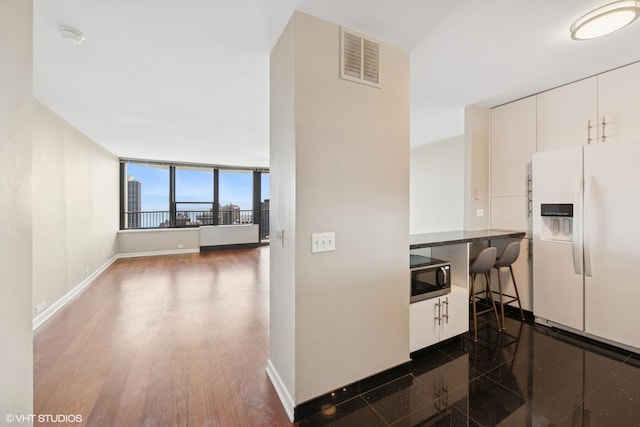 1560 N Sandburg Ter Unit 3506J, Chicago, IL 60610 - kitchen with white refrigerator with ice dispenser, white cabinetry, baseboards, and dark wood-style flooring