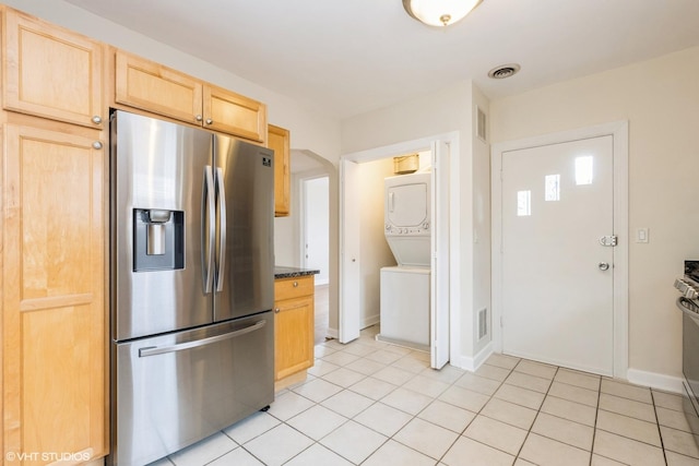6224 N Washtenaw Ave Unit 2, Chicago, IL 60659 - kitchen with stainless steel fridge with ice dispenser, estacked washer and dryer, light brown cabinetry, light tile patterned floors, and baseboards