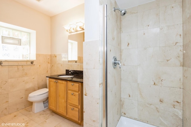 6224 N Washtenaw Ave Unit 2, Chicago, IL 60659 - bathroom featuring tile walls, a stall shower, vanity, toilet, and wainscoting