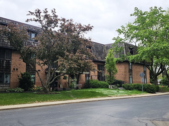 2 Oak Creek Dr Unit 3207, Buffalo Grove, IL 60089 - view of front facade featuring mansard roof, brick siding, and a front yard