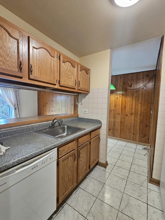 2 Oak Creek Dr Unit 3207, Buffalo Grove, IL 60089 - kitchen featuring dishwasher, a sink, dark countertops, brown cabinetry, and wooden walls