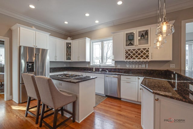 38868 Oakcrest Ln, Wadsworth, IL 60083 - kitchen with stainless steel appliances, a sink, a kitchen bar, white cabinets, and light wood-type flooring
