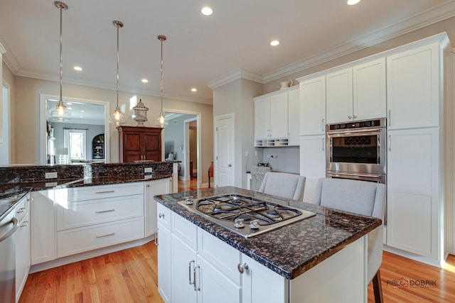 38868 Oakcrest Ln, Wadsworth, IL 60083 - kitchen featuring appliances with stainless steel finishes, light wood finished floors, white cabinetry, hanging light fixtures, and ornamental molding