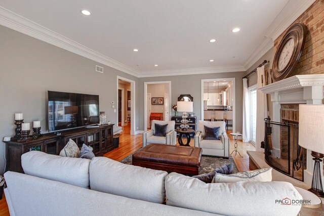 38868 Oakcrest Ln, Wadsworth, IL 60083 - living room featuring light wood-style floors, ornamental molding, a brick fireplace, recessed lighting, and baseboards
