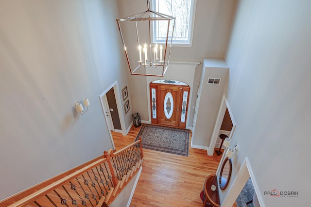 38868 Oakcrest Ln, Wadsworth, IL 60083 - entryway with a chandelier, a towering ceiling, light wood-type flooring, and baseboards