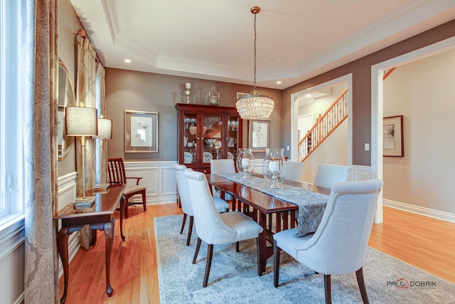 38868 Oakcrest Ln, Wadsworth, IL 60083 - dining space with a chandelier, crown molding, wood finished floors, a wainscoted wall, and stairs