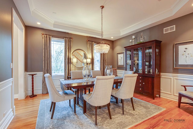 38868 Oakcrest Ln, Wadsworth, IL 60083 - dining room with a tray ceiling, light wood finished floors, a chandelier, a decorative wall, and crown molding