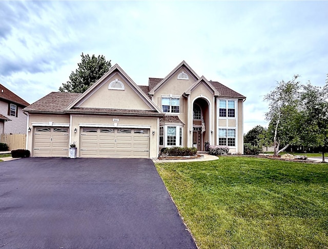 1849 Moorland Ln, Crystal Lake, IL 60014 - traditional-style home featuring a front lawn, driveway, stucco siding, and a garage