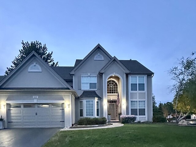 1849 Moorland Ln, Crystal Lake, IL 60014 - traditional-style home with a garage, a front lawn, concrete driveway, and stucco siding