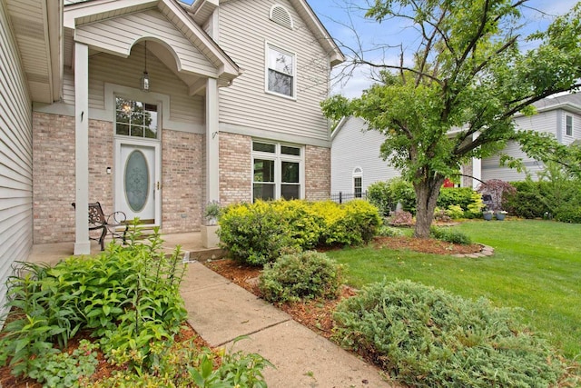 857 Bluestem Dr, Bolingbrook, IL 60440 - view of exterior entry with brick siding and a yard