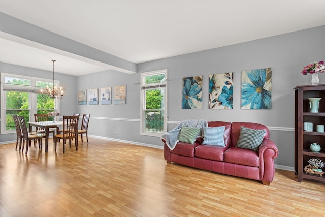 857 Bluestem Dr, Bolingbrook, IL 60440 - living room with a chandelier, light wood-style floors, baseboards, and healthy amount of natural light