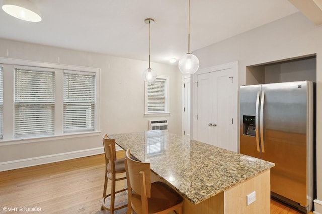 1620 W Olive Ave Unit 3A, Chicago, IL 60660 - kitchen featuring stainless steel fridge with ice dispenser, light wood-style flooring, baseboards, light stone counters, and a kitchen bar