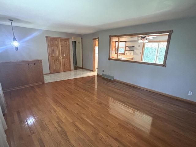 1 Marlin Dr, Oswego, IL 60543 - unfurnished living room with wood finished floors, a ceiling fan, and baseboards