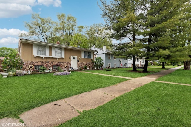 2110 Hermon Ave, Zion, IL 60099 - view of front of house featuring stone siding, a front lawn, a chimney, and board and batten siding