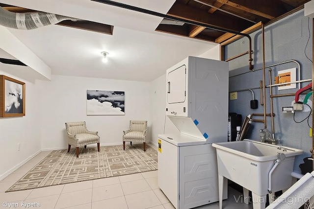 2110 Hermon Ave, Zion, IL 60099 - washroom with stacked washer and clothes dryer, light tile patterned floors, and baseboards