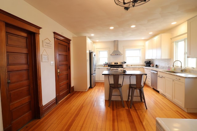 4977 N Mount Vernon Rd, Forreston, IL 61030 - kitchen featuring stainless steel appliances, wall chimney range hood, a sink, a kitchen bar, and white cabinets