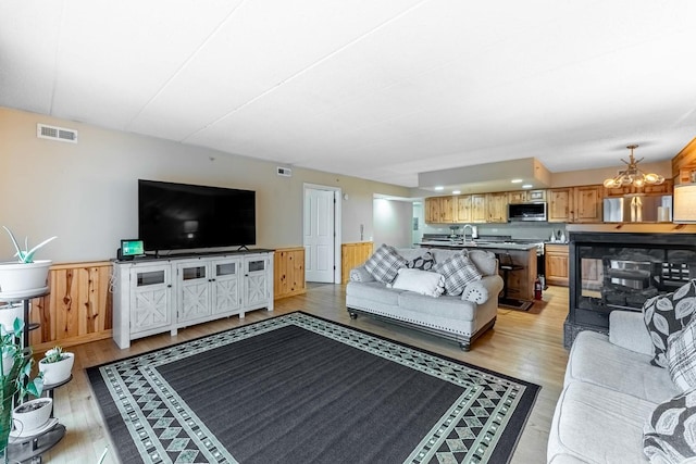 15505 Cicero Ave Unit 2C, Oak Forest, IL 60452 - living room with light wood-style flooring, a chandelier, and a wainscoted wall
