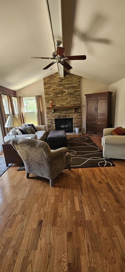 973 Willowbrook Dr, Wheeling, IL 60090 - living area with ceiling fan, wood finished floors, and a brick fireplace