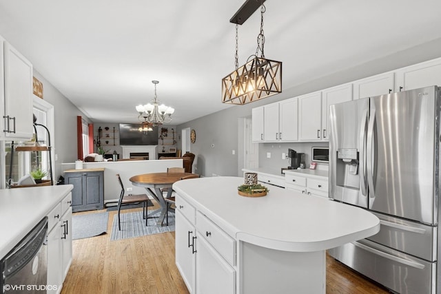 3175 N Magnolia Ln, Wadsworth, IL 60083 - kitchen with appliances with stainless steel finishes, a chandelier, light countertops, light wood-style flooring, and pendant lighting